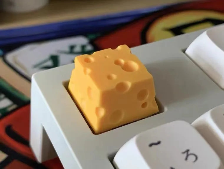 Yellow resin cheese artisan keycap for mechanical keyboards on a white background.