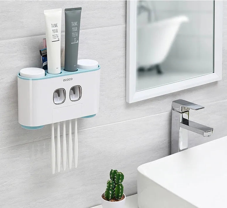 Plastic wall-mounted toothbrush holder with four magnetic cups in pink, blue, and green for family bathroom