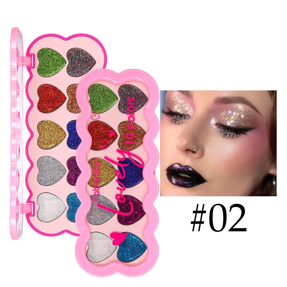 Heart-shaped case open to show ten eyeshadow pans in white, beige, pink, purple, brown, blue, black, royal blue, maroon, and coral.