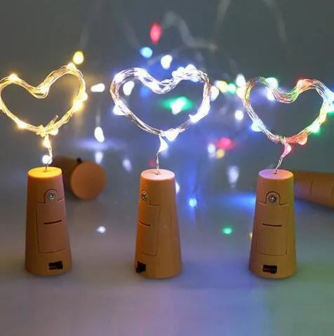 Silver copper wire LED string lights wrapped around a wine bottle with bottle stopper