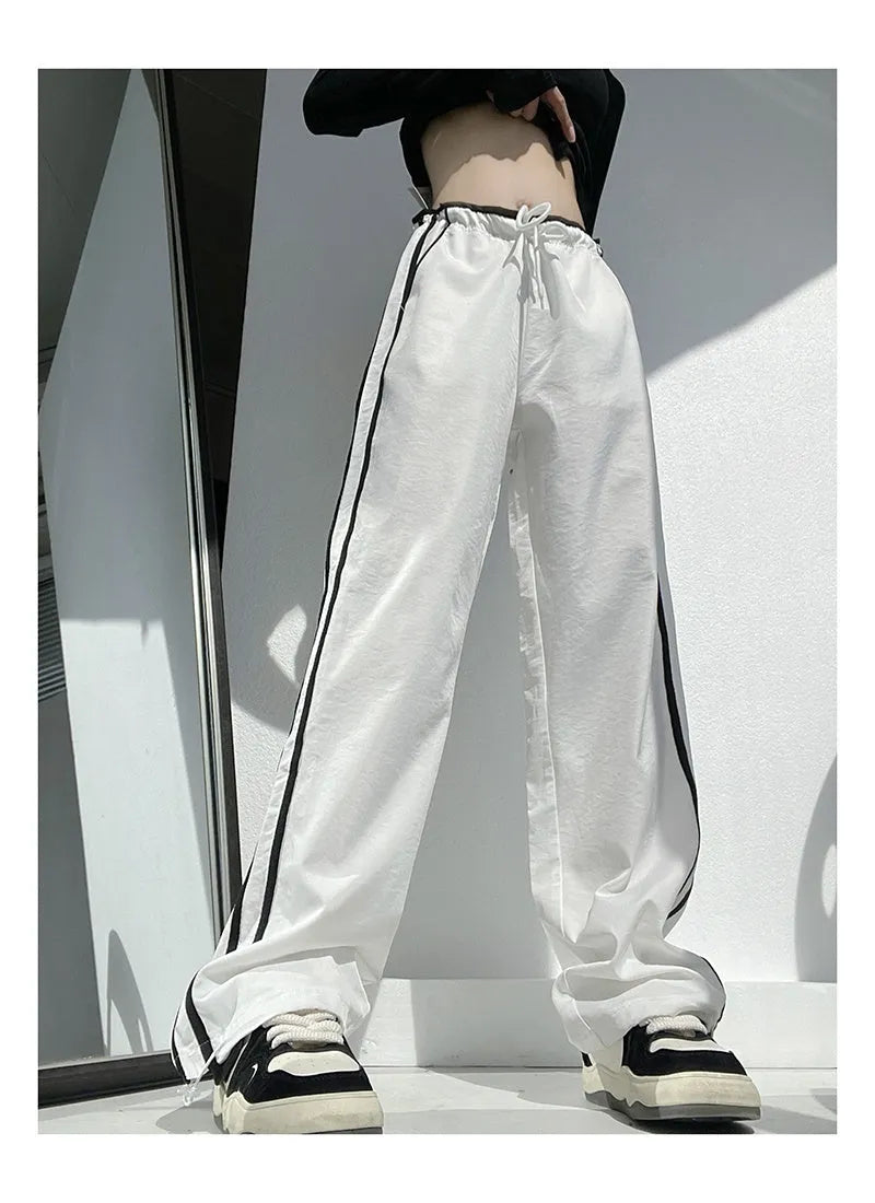 Women's navy blue loose straight leg trousers with ribbon parallel bars detail on the leg.