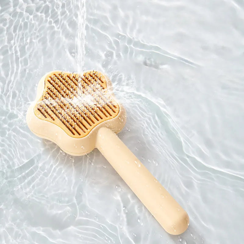 Green self-cleaning stainless steel pet comb with a magic wand handle on a white background.