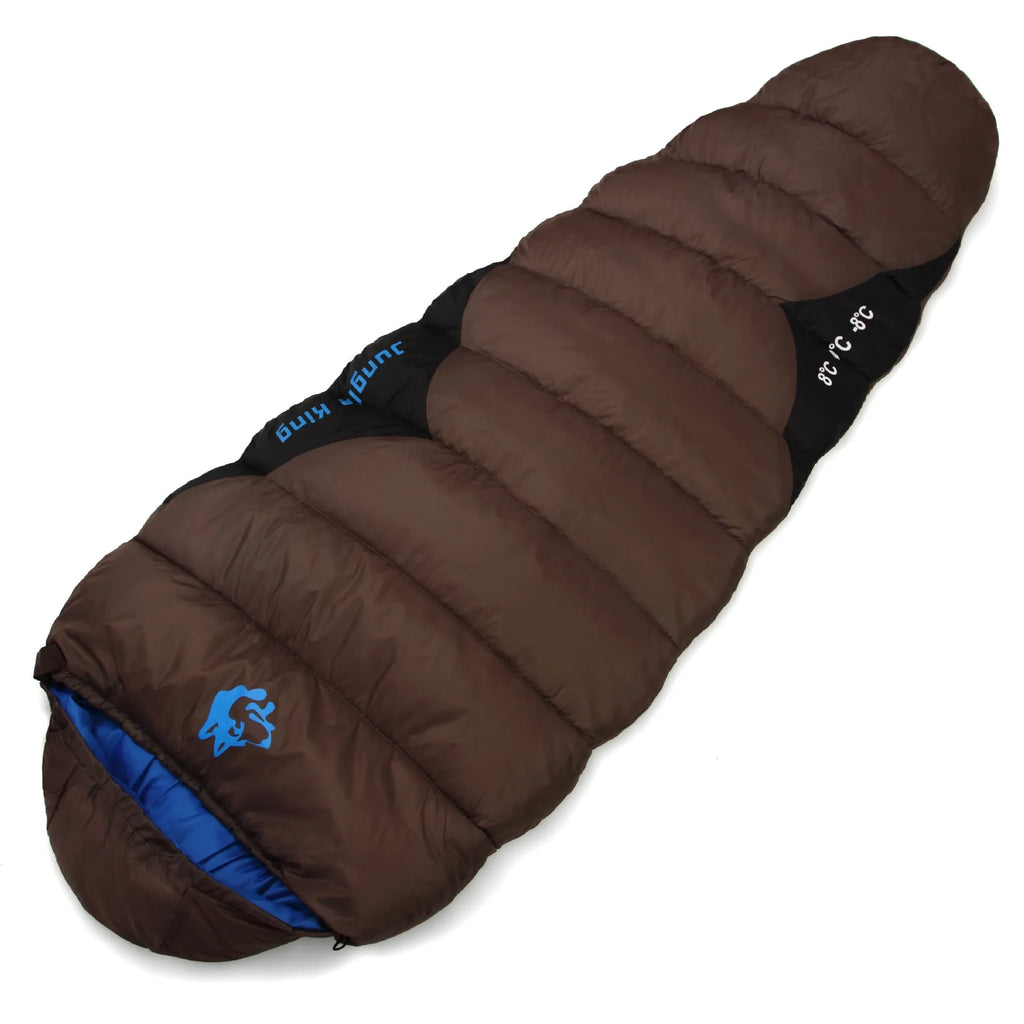 Outdoor cotton sleeping bag in Army Green with its compression storage sack laid beside it.