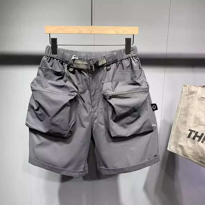 Man wearing loose fit black workwear shorts with pockets, showing above-the-knee length and straight leg style.