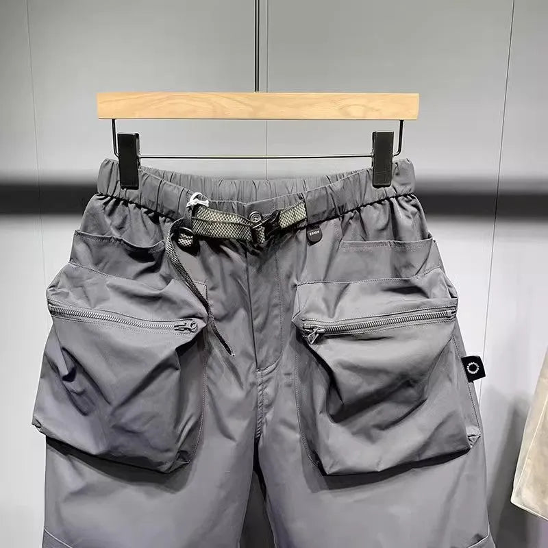 Man wearing loose fit black workwear shorts with pockets, showing above-the-knee length and straight leg style.