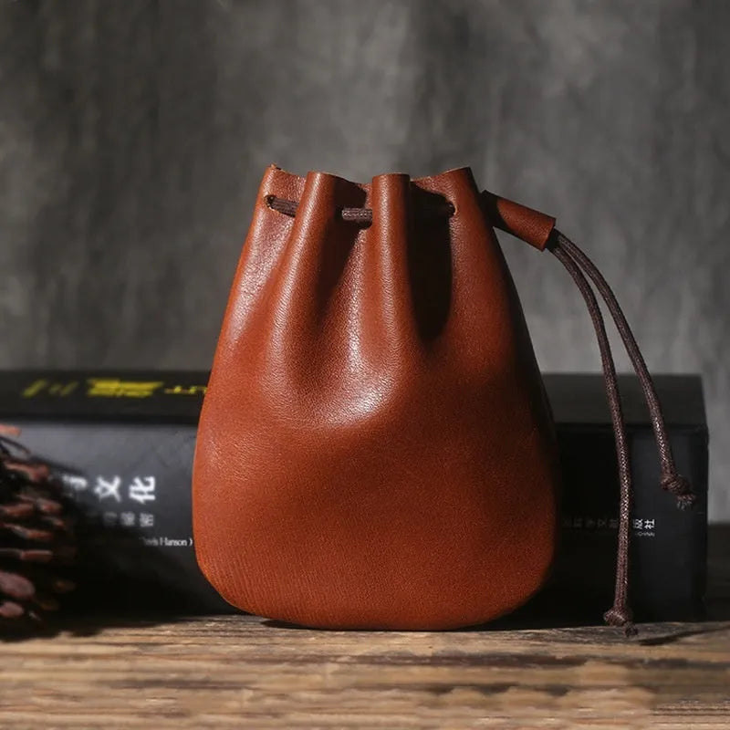 Vintage brown genuine cowhide drawstring bundle wallet laid flat, showing its retro style and stitching details.