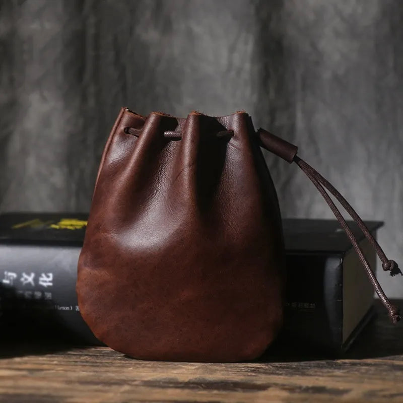Vintage brown genuine cowhide drawstring bundle wallet laid flat, showing its retro style and stitching details.