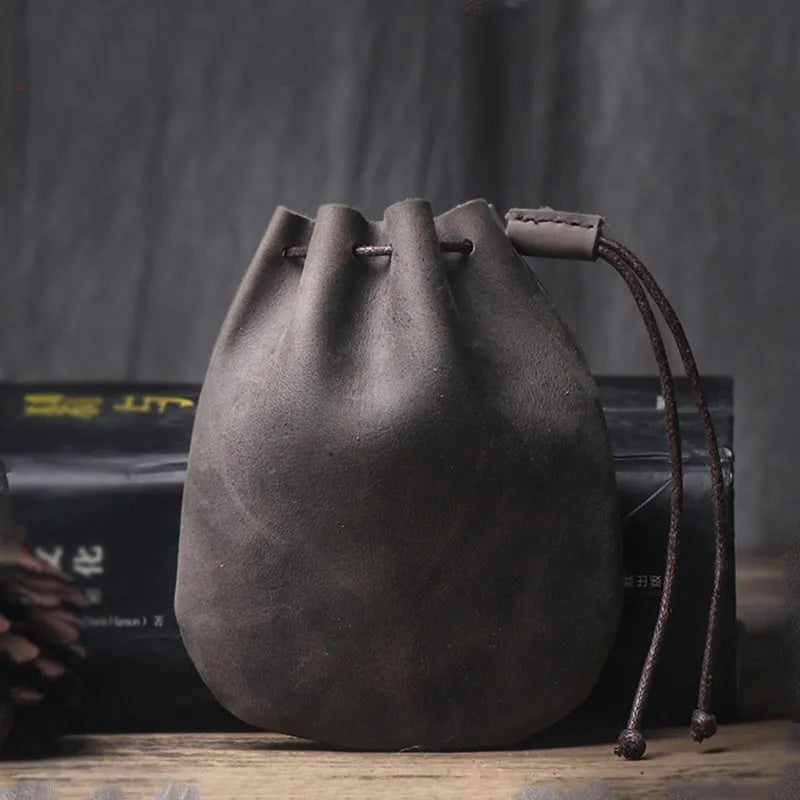 Vintage brown genuine cowhide drawstring bundle wallet laid flat, showing its retro style and stitching details.