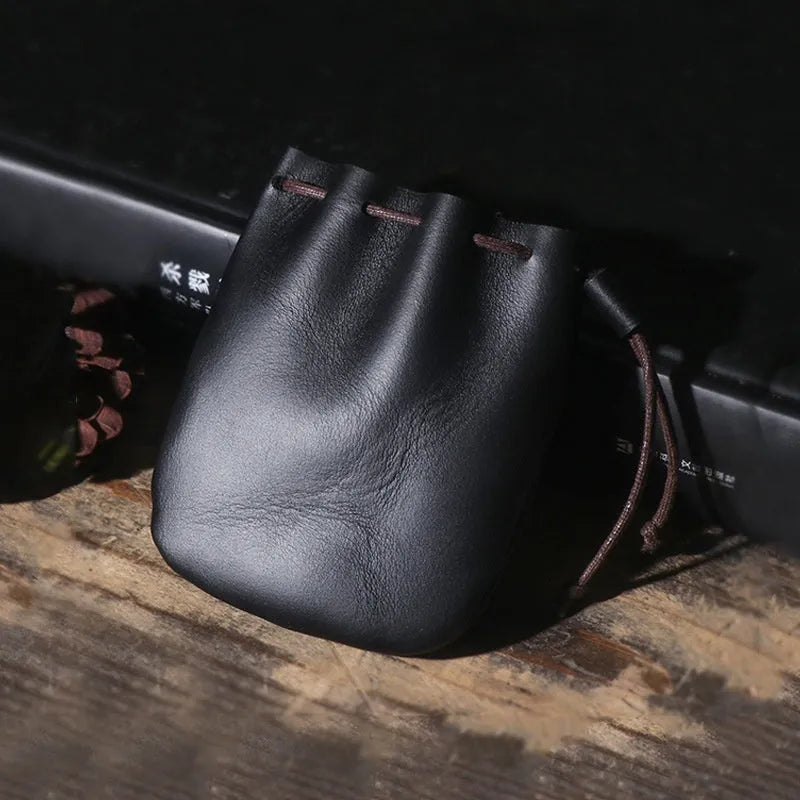 Vintage brown genuine cowhide drawstring bundle wallet laid flat, showing its retro style and stitching details.