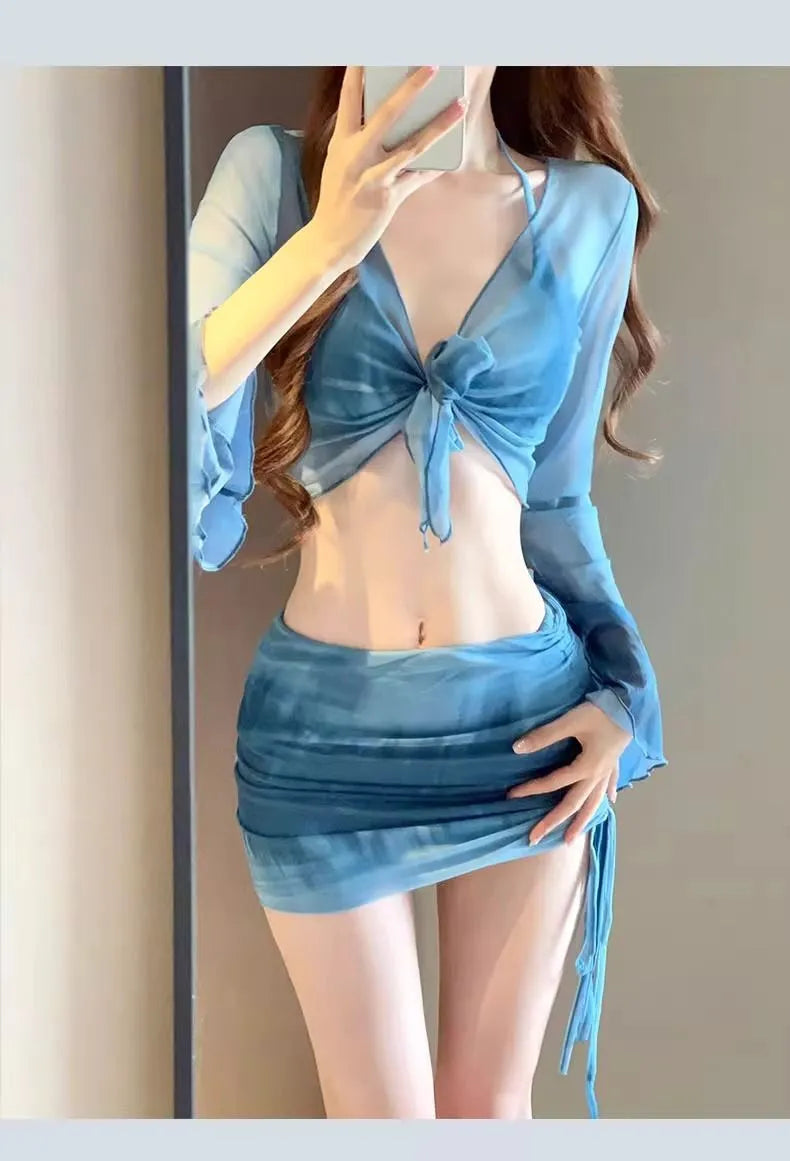 Women's blue four-piece bikini swimsuit set with shirt, bra, underwear, and skirt on hanger