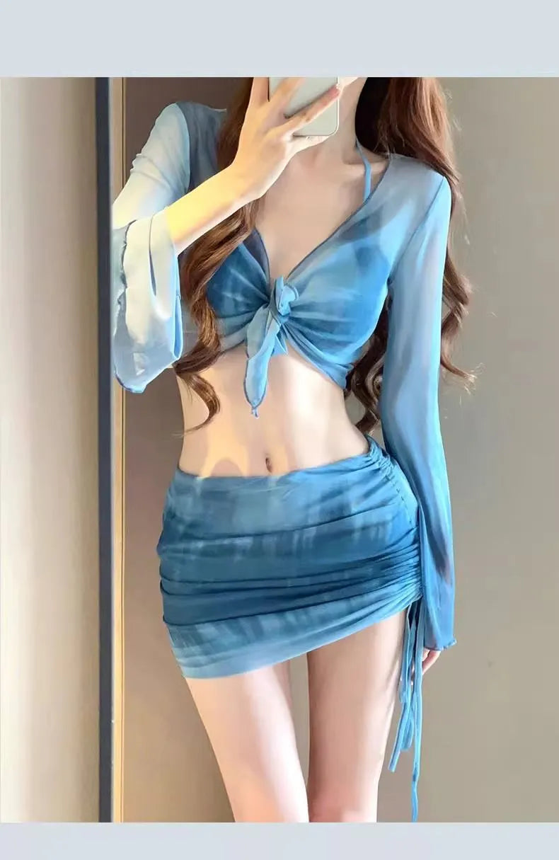 Women's blue four-piece bikini swimsuit set with shirt, bra, underwear, and skirt on hanger