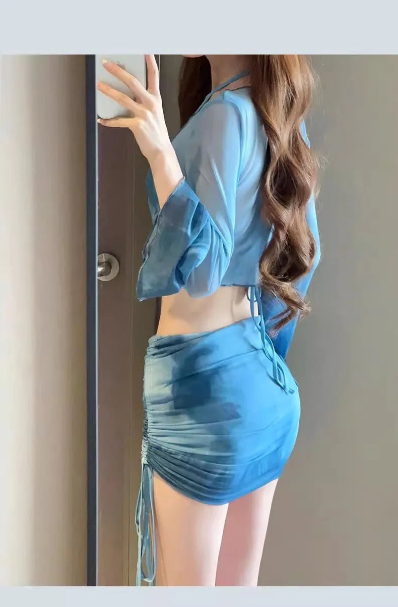 Women's blue four-piece bikini swimsuit set with shirt, bra, underwear, and skirt on hanger