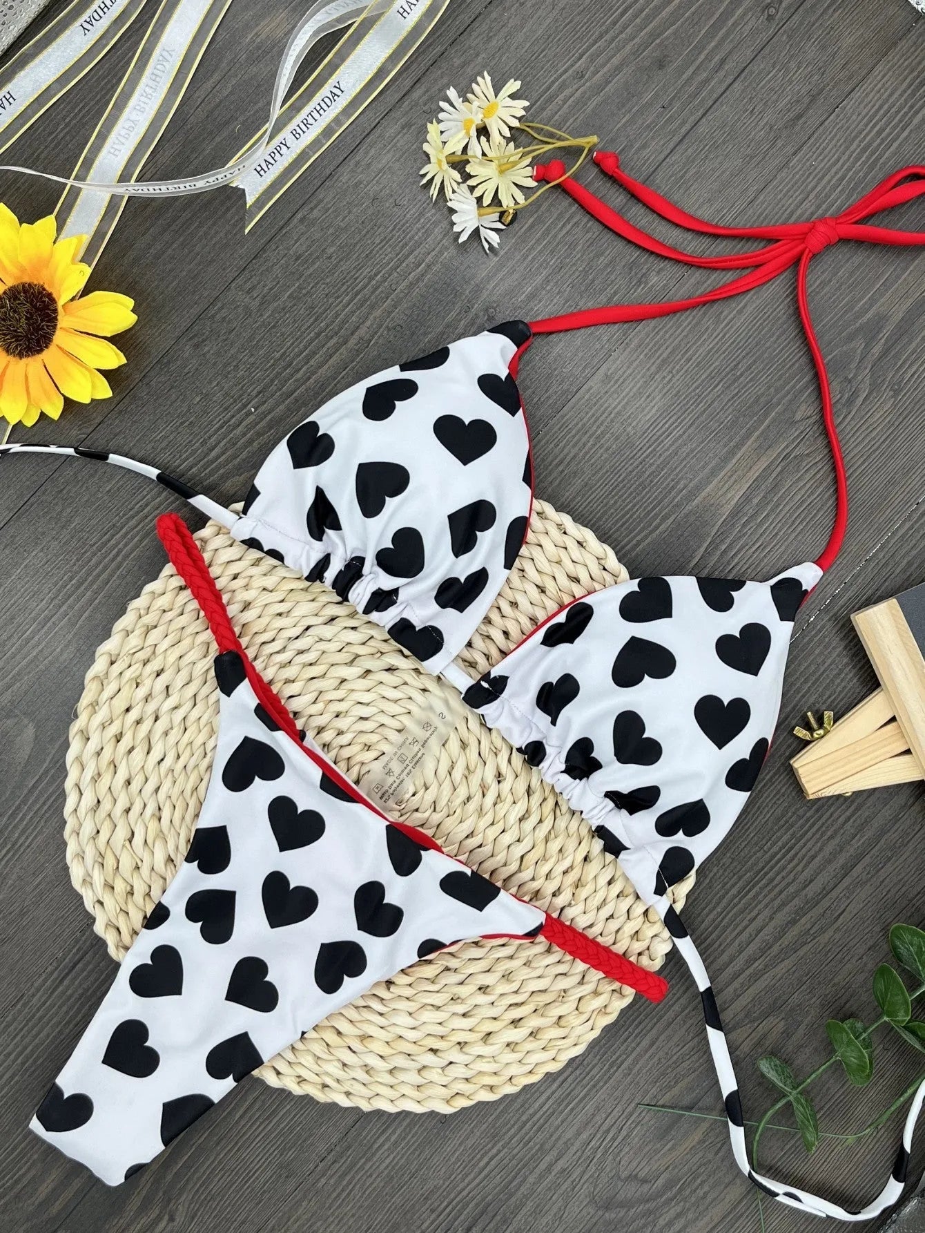 Heart print backless one-piece swimsuit with a split briefs style on a mannequin.