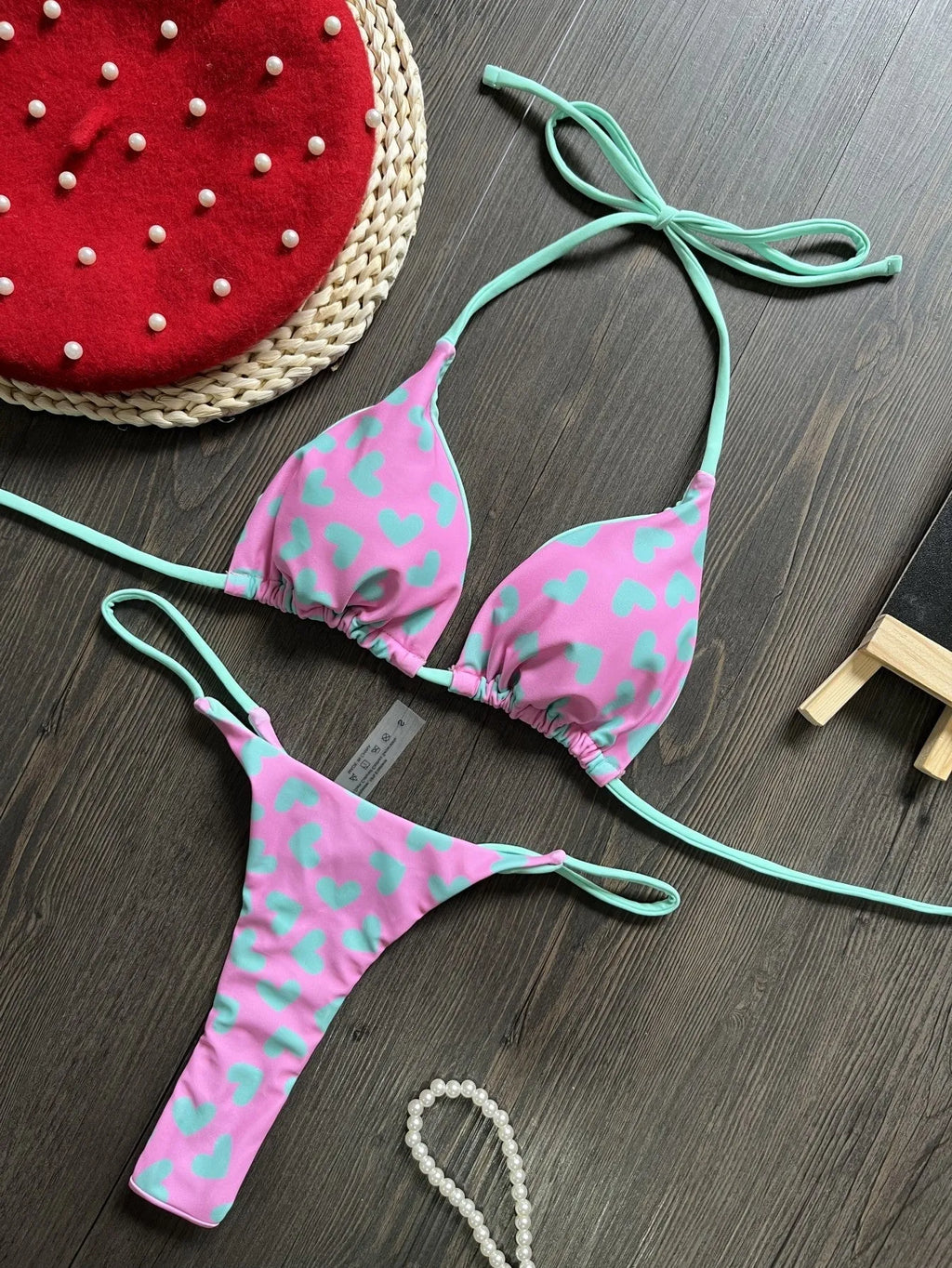 Heart print backless one-piece swimsuit with a split briefs style on a mannequin.