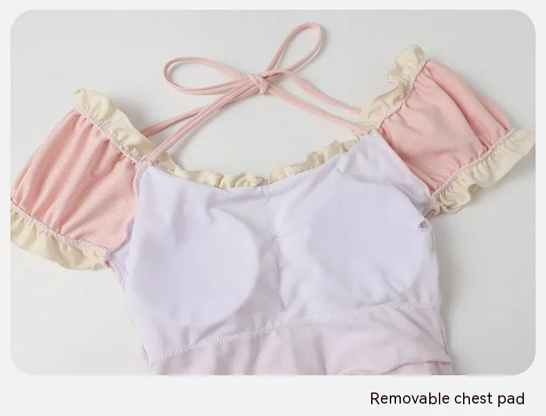 Pink women's conservative one-piece swimsuit made from nylon fabric on a mannequin.