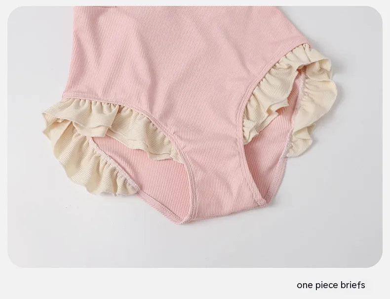 Pink women's conservative one-piece swimsuit made from nylon fabric on a mannequin.
