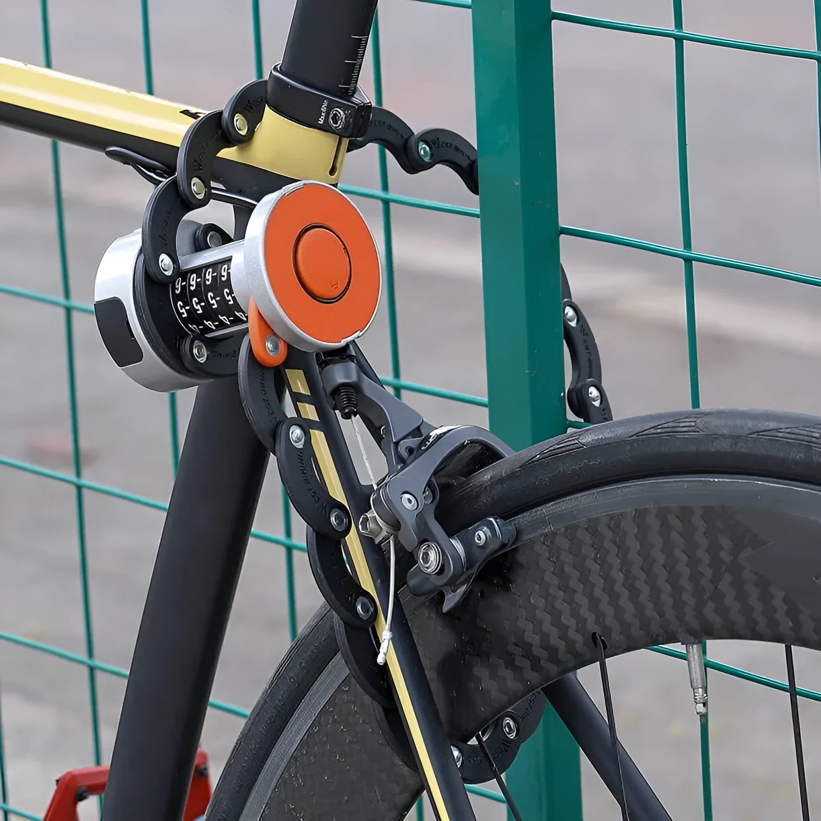 Portable black and black-orange bicycle folding lock made from zinc alloy and steel on a plain background.