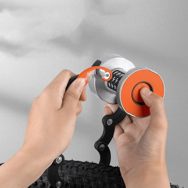 Portable black and black-orange bicycle folding lock made from zinc alloy and steel on a plain background.