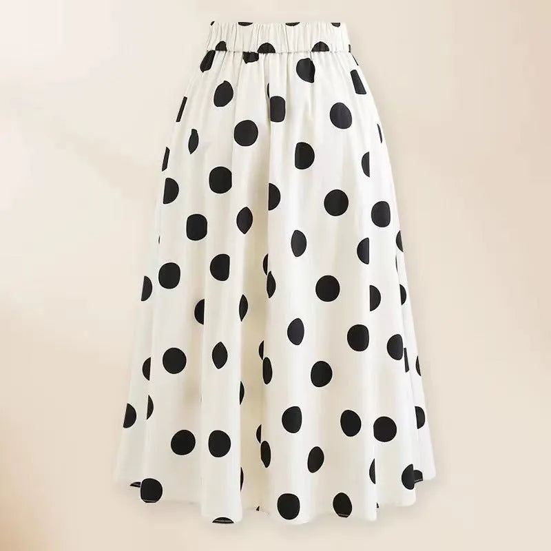 Women's black one-piece swimsuit with a white bow-accented beach dress cover-up skirt.