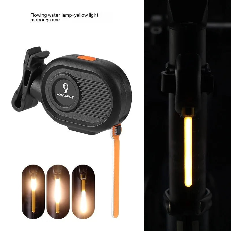 Bicycle rear safety taillight displaying a colourful running water or waterfall light effect on a black background.
