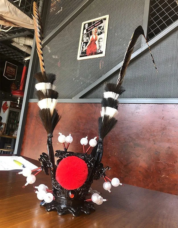 Motorcycle helmet decoration kit showing a crown ornament and a long feather for customisation.