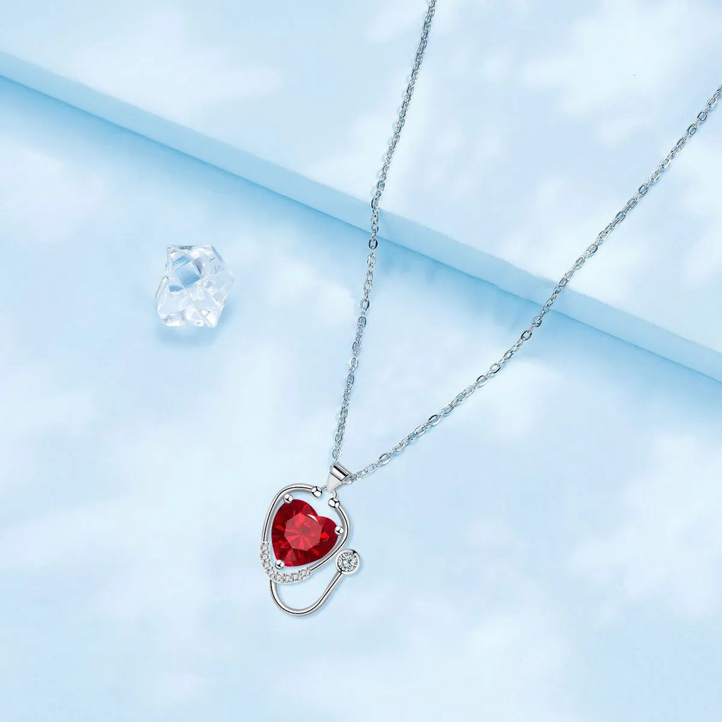 Women's copper necklace with cross, wings, and stethoscope charm in red diamond colour.