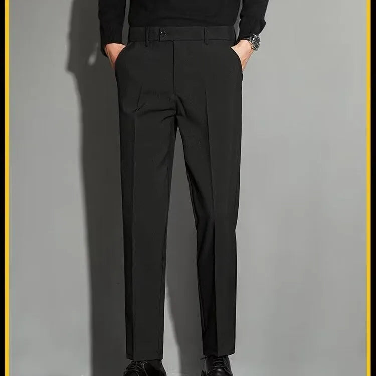 Man wearing straight leg ankle-length suit trousers in a light colour, showing the drape of the fabric.
