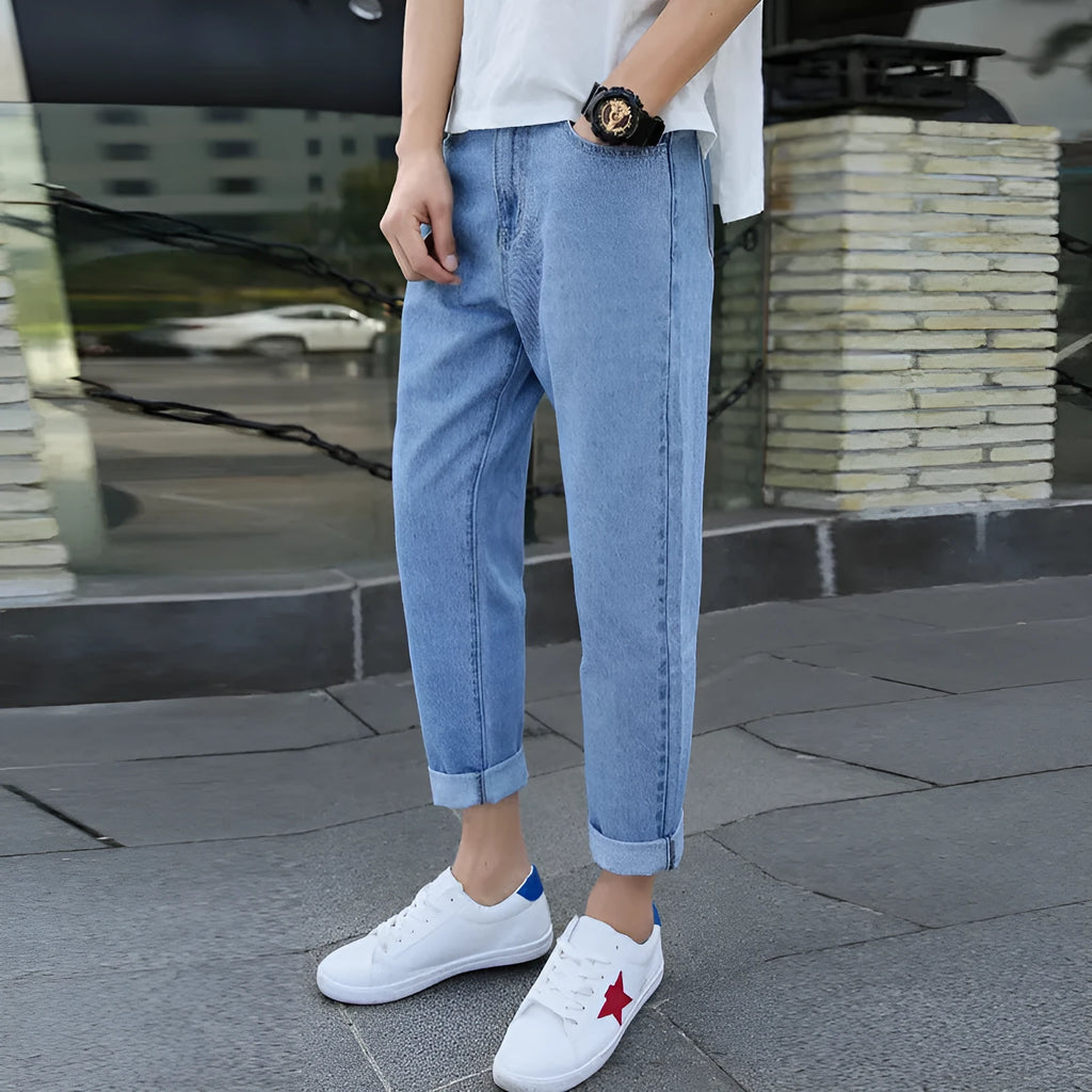 A pair of men's loose straight-leg jeans in a blue colour on a plain background.