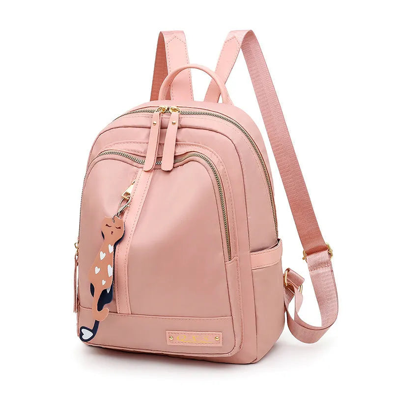 Black nylon casual travel backpack with double shoulder straps, external pockets, and a soft handle on a solid background.