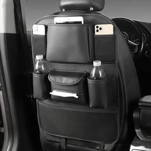 Leather car seat back storage bag in brown, hanging from a car headrest.