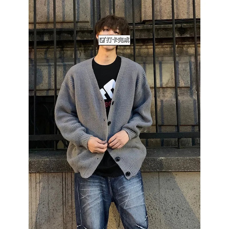 Men's loose fit V-neck knitted cardigan sweater in a solid colour on a hanger.