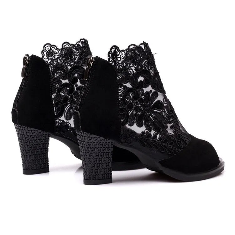 Black lace gladiator sandals with a square high heel and peep toe on a woman's foot