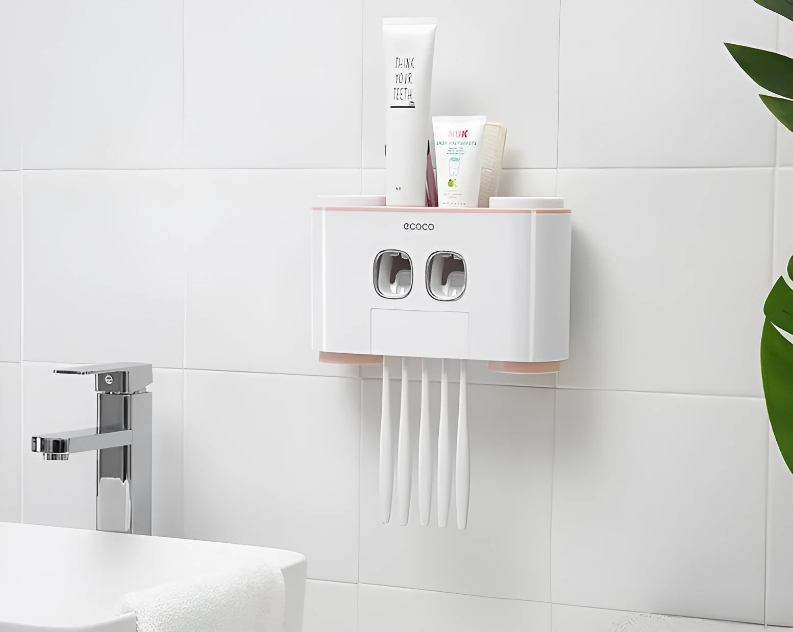 Plastic wall-mounted toothbrush holder with four magnetic cups in pink, blue, and green for family bathroom