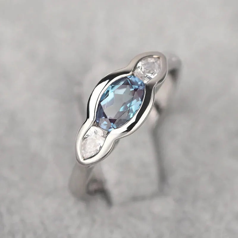 Geometric ellipse women's ring with a central zircon stone and white gold plating.