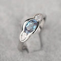 Geometric ellipse women's ring with a central zircon stone and white gold plating.