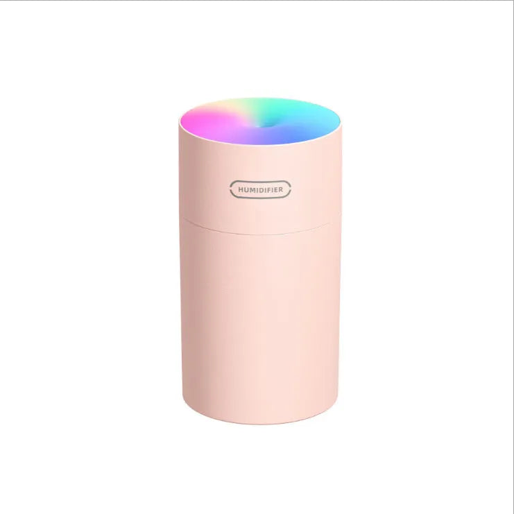Pink USB mini humidifier with LED lights and water tank on desk