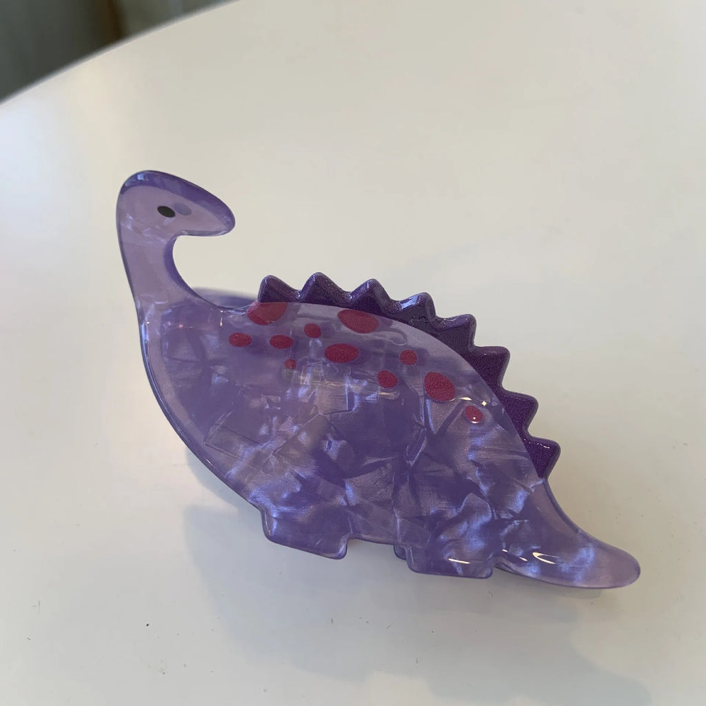 A colourful acrylic jaw clip hair grip featuring a detailed little dinosaur design.