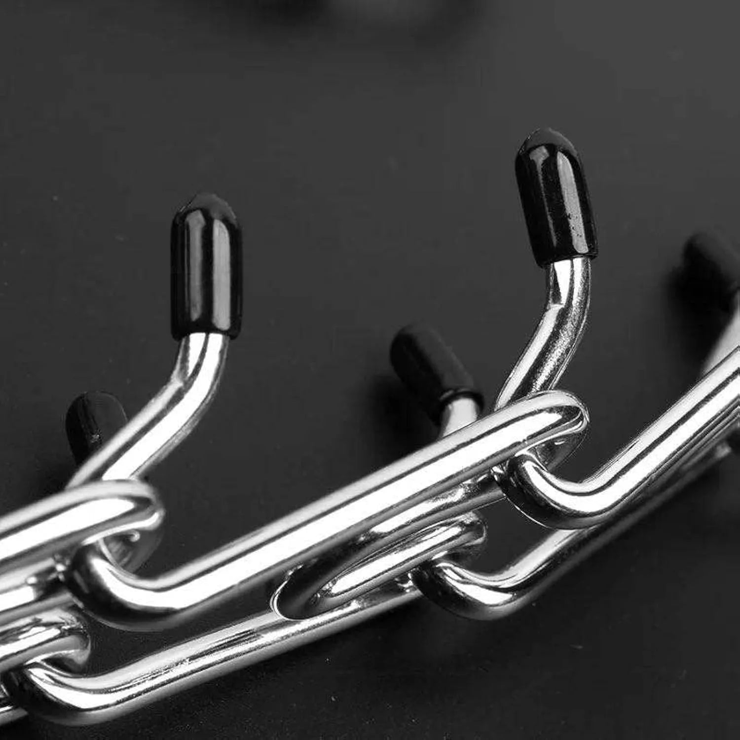 Stainless steel dog prong training collar with black rubber comfort tips, shown with adjustable chain links.