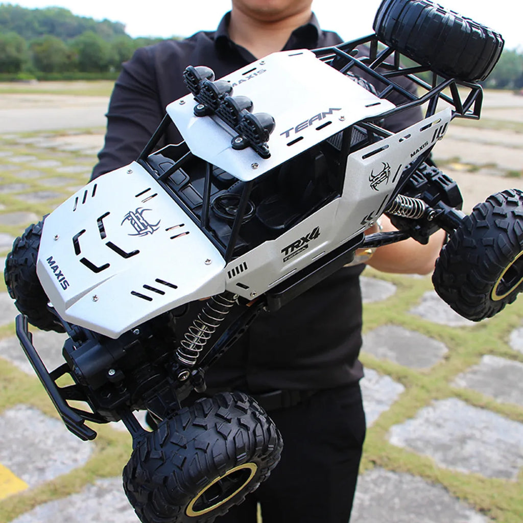 Black and silver remote control climbing cars with 2.4G wireless controller on a rough surface.