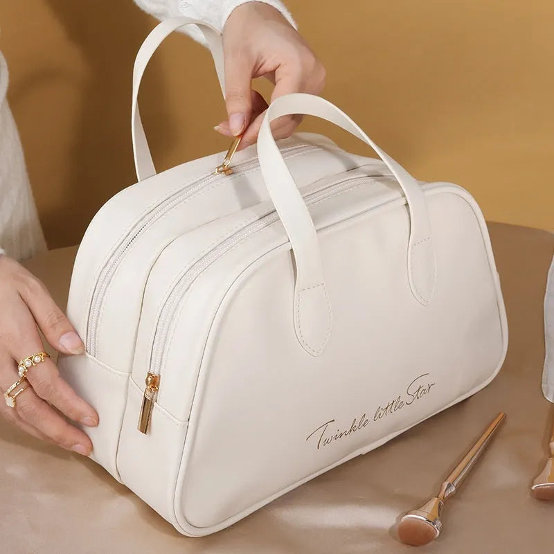 Leather travel toiletry bag in caramel mocha colour showing storage compartments and decorative letter details