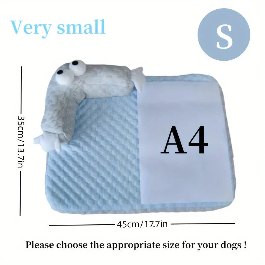 Blue pet bed cushion with a big-eyed monster design on a wooden floor.