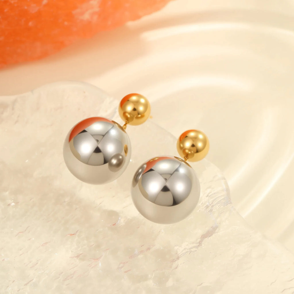 A pair of round bead stainless steel stud earrings with a colour-block geometric design.