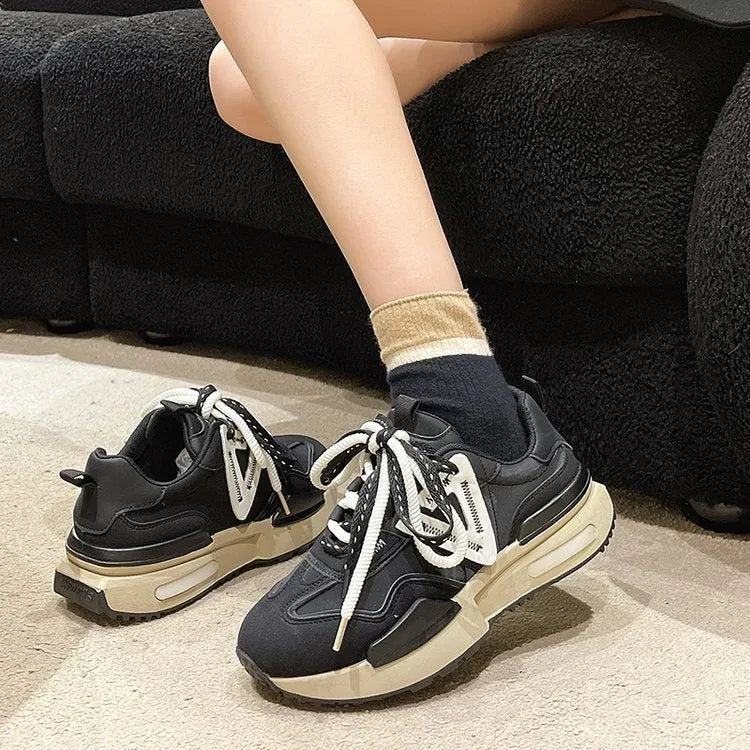 Women's retro platform sports shoes in black with mesh lining and rubber sole, shown from the side.