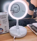 White foldable LED vanity mirror with open storage compartments and USB charging port.