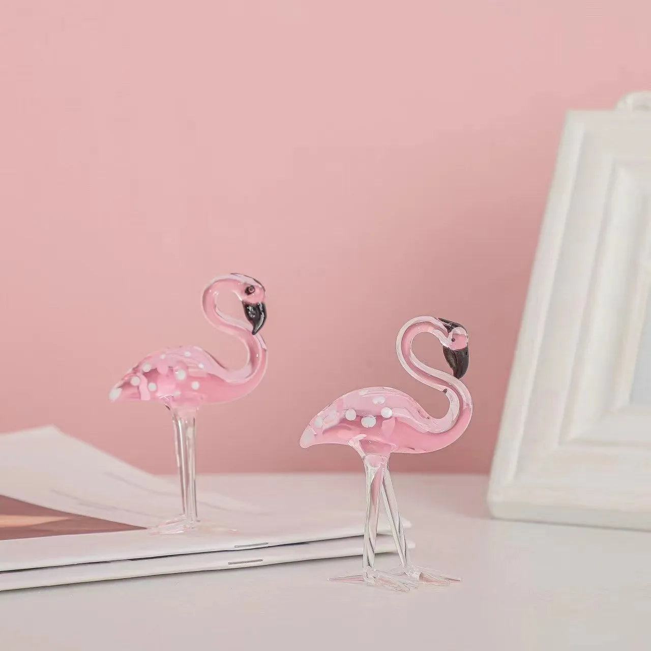 Pink crystal flamingo decorative ornament on table, available in separate or parallel styles.