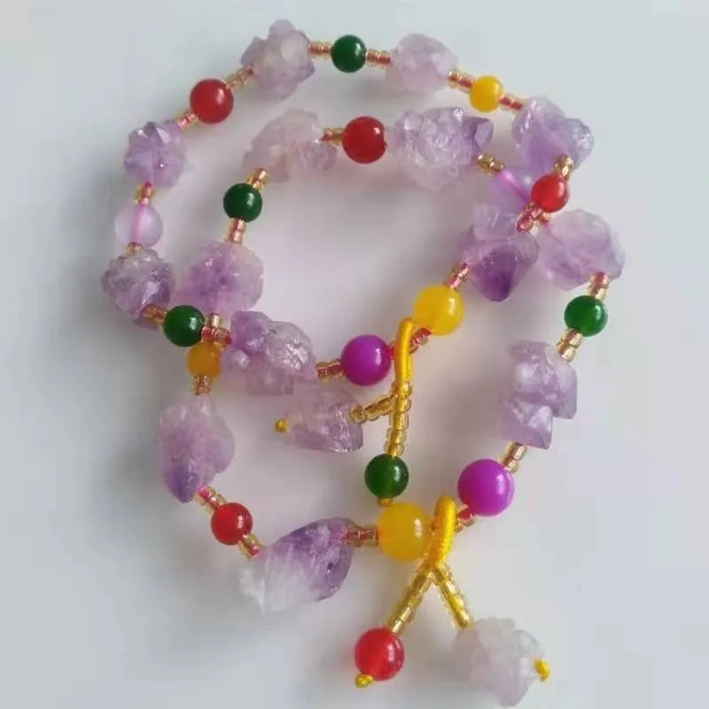 Close-up of a purple natural amethyst bead bracelet with a fu charm for women, on a white background.