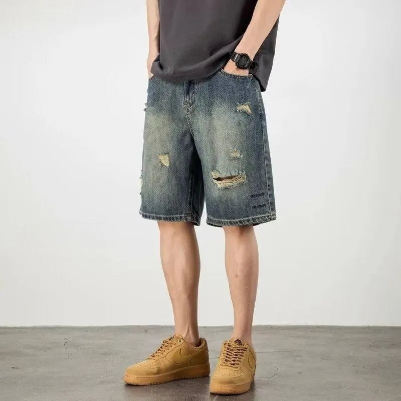 Man wearing blue retro distressed denim shorts with a straight leg cut.