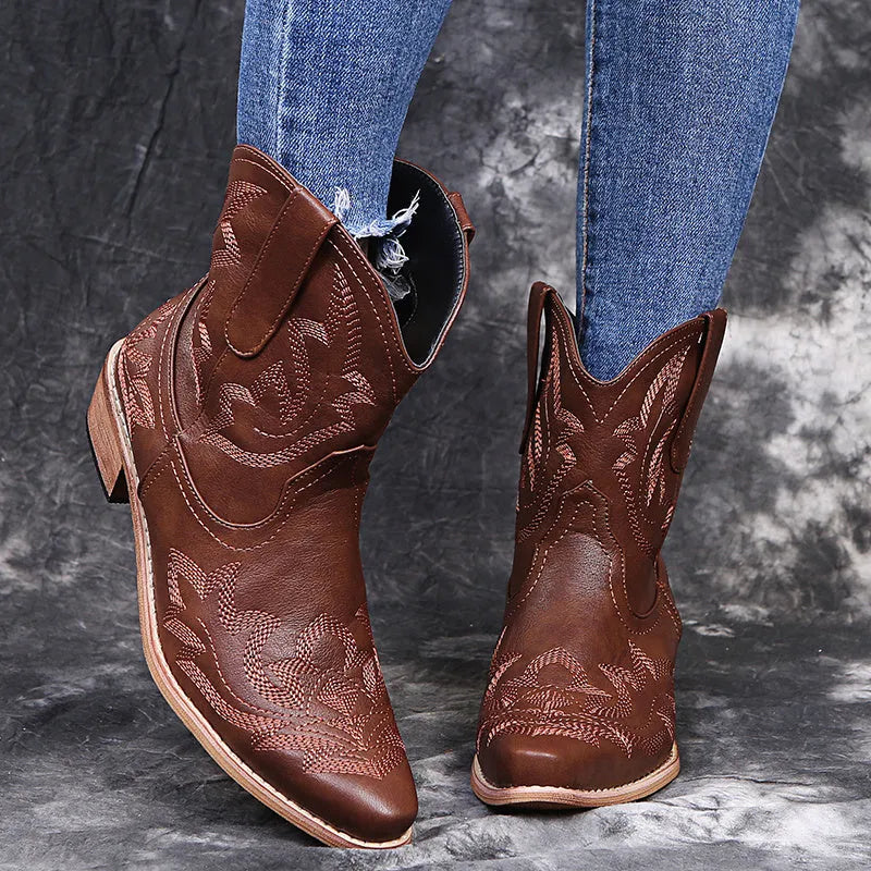 Blue women's cowboy ankle boots with embroidery, a pointed toe, and a low wedge heel.