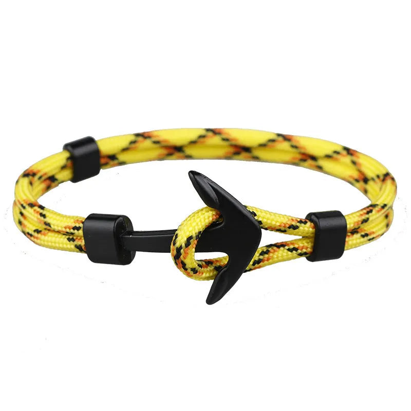 Anchor bracelet with black cotton linen rope and brass alloy anchor charm on white background