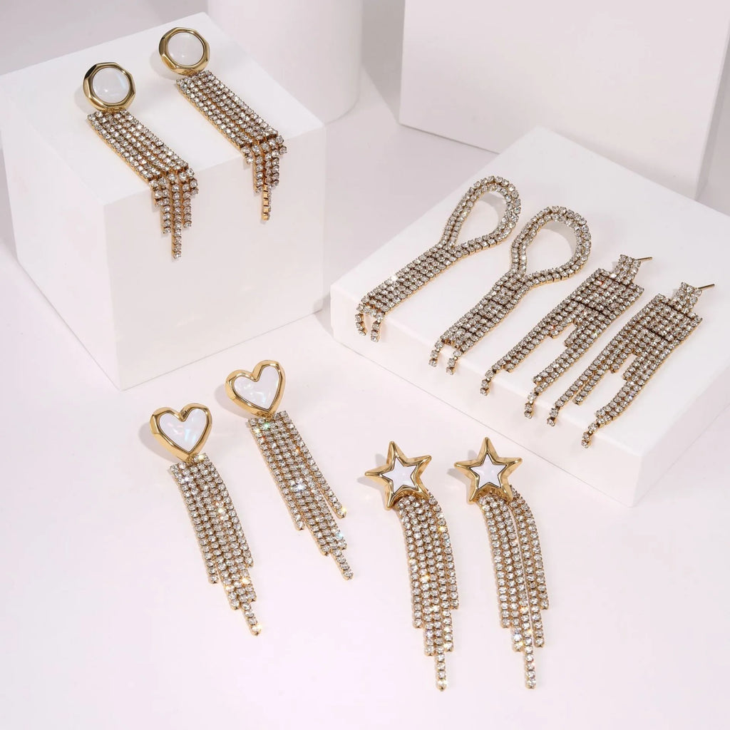 Gold electroplated stainless steel fashion earrings with heart, star, and geometric tassel design.